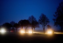 Autos fahren in der Abenddämmerung über eine Landstraße - Julian Stratenschulte/dpa/dpa-tmn