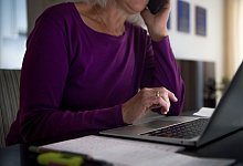 Eine Frau sitzt zu Hause an einem Esstisch am Laptop - Finn Winkler/dpa/dpa-tmn