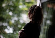 Eine Frau schaut nachdenklich aus dem Fenster - Fabian Sommer/dpa/dpa-tmn