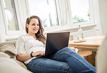 Eine Frau mit Laptop auf dem Sofa - Christin Klose/dpa-tmn Eine Frau mit Laptop auf dem Sofa - Christin Klose/dpa-tmn