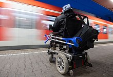 Mann im Rollstuhl steht am Bahnhof an einem Gleis - Marijan Murat/dpa/dpa-tmn