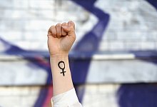 Eine Frau hebt ihre Faust mit Venussymbol die Höhe - Elisa Schu/dpa/dpa-tmn