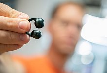 Mann hält die Moto Buds Loop von Motorola in der Hand - Nico Tapia/dpa-tmn