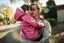 Ein Mann trägt seine Tochter auf dem Arm - Christin Klose/dpa-tmn