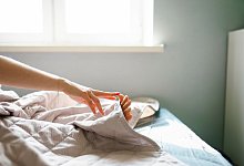 Eine Frau berührt ihre Zehen mit ihren Fingern - Vyacheslav Chistyakov/Westend61/dpa-tmn