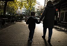EineFrau hält ein Kijd an der Hand - Christin Klose/dpa-tmn