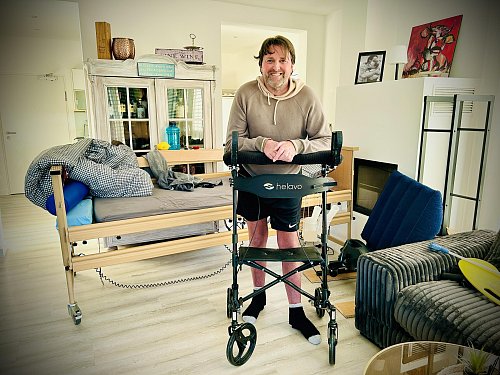 Sven Heibrock in seiner behindertengerechten Wohnung, wie er sich auf seinen Arthritis-Rollator stützt. - © Nicole Donath
