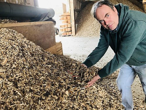 Das sind Holzschnitzel in Premiumqualität. Bernward Krause lässt die feinen Holzstücke durch seine Hände rieseln um zu beweisen, dass sie Staub- und Rindenfrei sind. - © Herbert Gontek