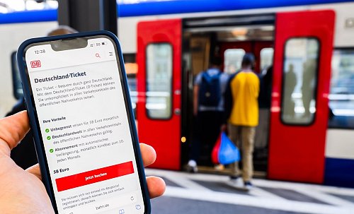 Eine Information zum Kauf des Deutschlandtickets ist auf dem Display eines Smartphones am Hauptbahnhof Hannover zu sehen. (Illustration) - © Julian Stratenschulte/dpa