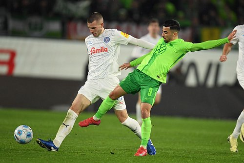 Wolfsburgs Mohamed Amoura (r) spielt gegen Kiels David Zec. - © Swen Pförtner/dpa