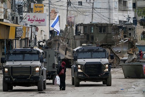 Israelische Militärfahrzeuge bewachen eine Straße in Dschenin. Die Stadt gilt als Hochburg militanter Palästinenser. - © Majdi Mohammed/AP/dpa