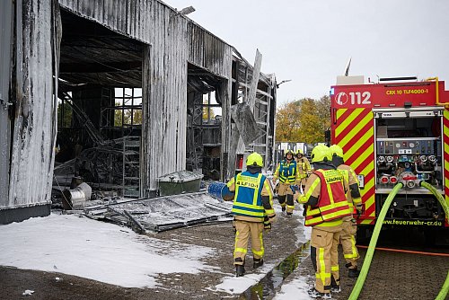 Feuerwehrleute bei Löscharbeiten an der Halle - am frühen Samstagmorgen mussten sie noch mal ausrücken (Archivbild) - © Bernd Thissen/dpa