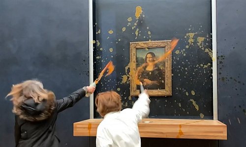 Zwei Umweltaktivistennen im Pariser Louvre. - © David Cantiniaux/AFPTV/AFP/dpa