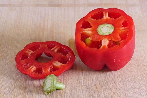 2. Schritt: Drehe nun die Paprika auf dem Brett um 180 Grad und schneide auch den Boden der Paprika ab. Jetzt hast du einen Paprika-Zylinder vor dir. - © Katharina Frenzel/mehr-genuss.de/dpa-tmn