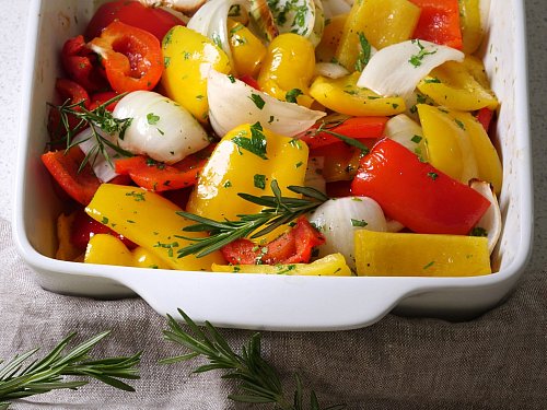 Gelbe Paprika, rote Paprika, Knoblauch, Zwiebeln und Mandelblättchen sind die Hauptzutaten für die raffinierte Ofenpaprika, die für rund 30 Minuten im Ofen gart. - © Katharina Frenzel/mehr-genuss.de/dpa-tmn
