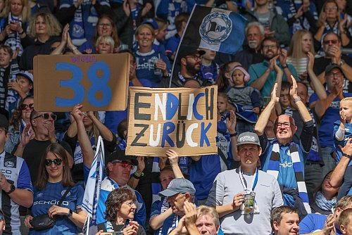 Die Fans von Arminia Bielefeld feiern die Rückkehr von Marius Wörl. - © Friso Gentsch/dpa