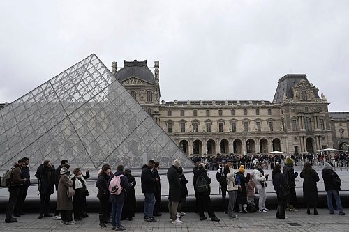 Menschen stehen vor den Louvre Schlange. - © Thibault Camus/AP/dpa