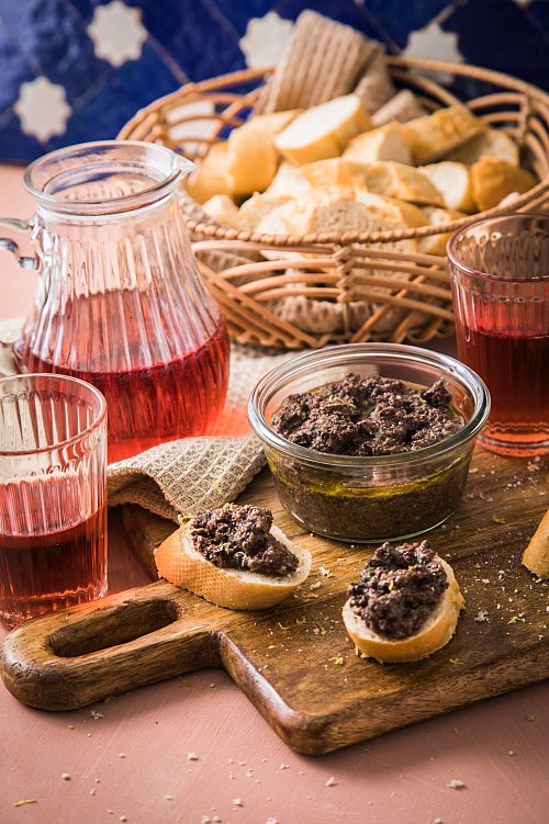 Wer Inspiration für Amuse-Gueules sucht, wird in den Mittelmeerküchen fündig. Eine Idee: Oliventapenade mit Zitronenzesten, Baguette und Roséwein. - © Christin Klose/dpa-tmn