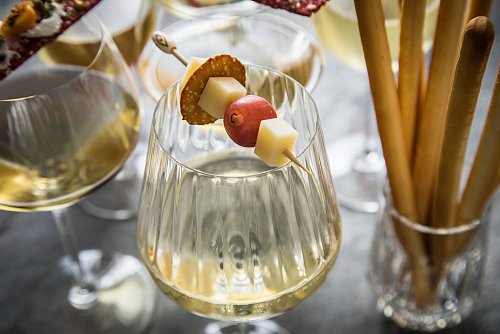 Weißwein mit Käsebegleitung: Kleine Spießchen auf dem Glasrand setzen Emmentaler und Co. in Szene. Spannend ist der Wechsel zwischen Käsehäppchen und Bretzel-Ring und Trauben. - © Christin Klose/dpa-tmn