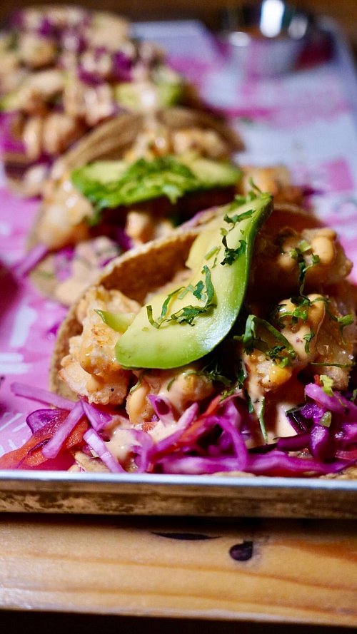 Es muss nicht immer gezupftes Fleisch sein: Auch kleine gebratene Fisch-Flöckchen mit Avocado machen den Taco lecker. - © Andres Besson/dpa-tmn