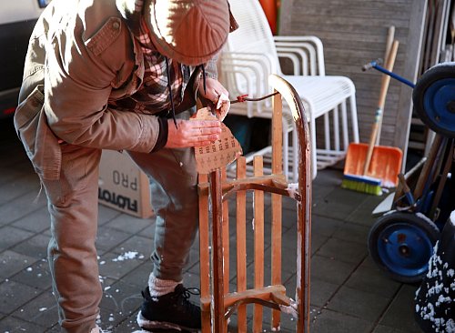 Vor dem ersten Rodeln im Winter sollte man mit Schleifpapier Rost von den Kufen entfernen. - © Mascha Brichta/dpa Themendienst/dpa-tmn