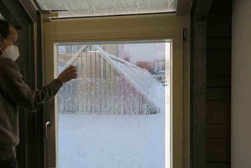 Die Restfeuchtigkeit entfernen Sie am besten mit einem Rakel. In diesem Fall wurde zur besseren Veranschaulichung die Folie ausnahmsweise innen angebracht. - © Stiftung Warentest/dpa-tmn