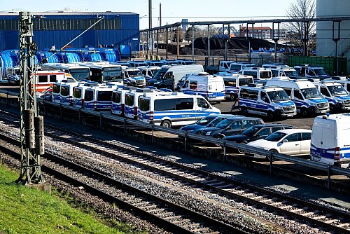Zahlreiche Einsatzfahrzeuge stehen an der Bahnstrecke am Hafen. - © Sina Schuldt/dpa