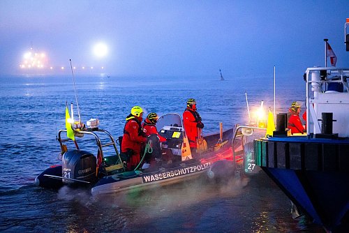 Einsatzkräfte der Wasserschutzpolizei sichern den Hafen, in dem das Spezialschiff «Pacific Grebe» angelegt hat. - © Sina Schuldt/dpa