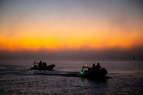 Einsatzkräfte begleiteten das Schiff bei seiner Ankunft in der Dämmerung. - © Sina Schuldt/dpa