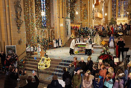 Im Dom von Paderborn fiel bei der Aktion Dreikönigssingen Konfetti in der Form von Sternen auf die Sternsinger nieder. - © Friso Gentsch/dpa