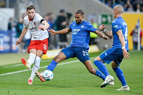 Der 1. FC Heidenheim um Marvin Pieringer (l) und die TSG 1899 Hoffenheim um Kevin Akpoguma (r) lieferten sich in der Anfangsphase einen müden Kick. - © Uwe Anspach/dpa