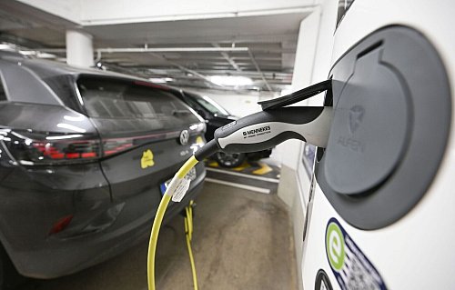 Ein Elektrofahrzeug ist in einer Tiefgarage mit einem Stromkabel zum Laden an eine E-Ladesäule angeschlossen. - © Bernd Weißbrod/dpa