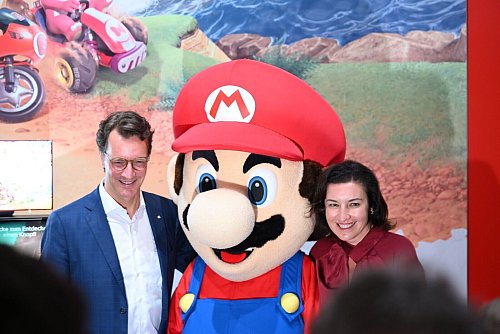 Beim Messerundgang über die Gamescom kam der Tross von Politikern auch beim Messestand von Nintendo vorbei, hier stehen NRW-Ministerpräsident Hendrik Wüst (CDU) und Bundesforschungsministerin Dorothee Bär (CSU) neben einer Mario-Plüschfigur. - © Wolf von Dewitz/dpa