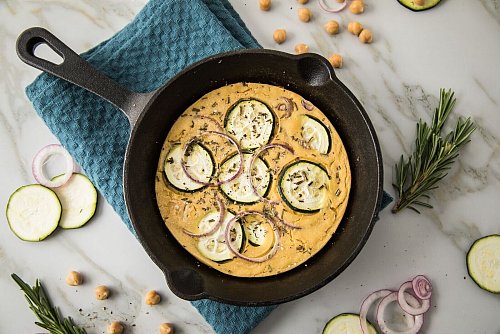Socca ist eine südfranzösische Fladenbrot-Spezialität. Hier ist die Socca-Pizza aus Kichererbsenmehl mit Zucchini, Rosmarin und roten Zwiebeln belegt. - © Christin Klose/dpa-tmn