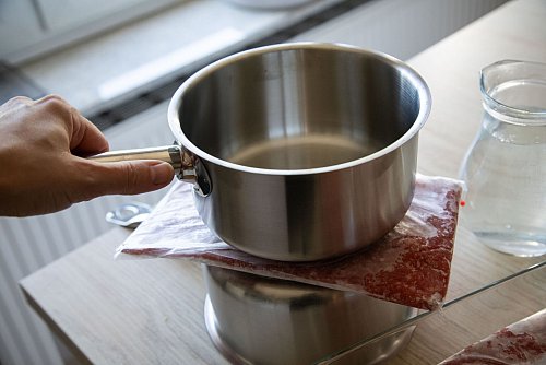 Schritt 1: Das Hackfleisch in einem Gefrierbeutel auf einen umgedrehten Topf legen, einen weiteren Topf daraufstellen. - © Christin Klose/dpa-tmn