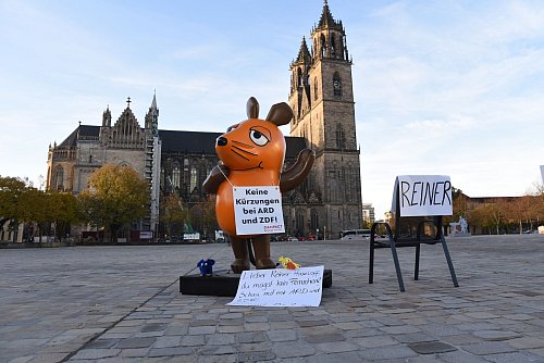 Die von Aktivisten "entführte" Maus protestiert in Magdeburg gegen Kürzungen beim öffentlich-rechtlichen Rundfunk. - © Simon Kremer/dpa