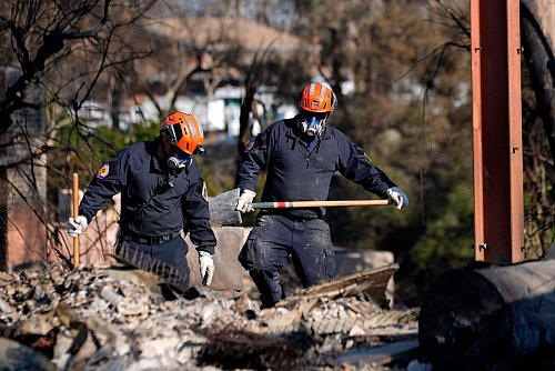 In den Brandruinen wird auch noch nach möglichen Opfern gesucht. - © Richard Vogel/AP/dpa