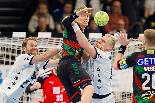 Magdeburgs Gisli Kristjansson wird von der Kieler Abwehr gestoppt. - © Frank Molter/dpa