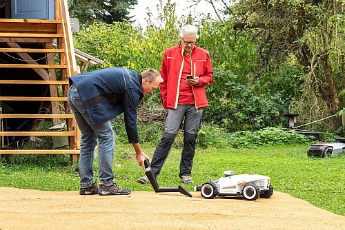 TÜV-Experte Alexander Baumstark (l) und Peter Carla Baruschke von der Zeitschrift «Selbst ist der Mann» beim Sicherheits-Check der Mähroboter. - © Michael Müller-Münker/selbst ist der Mann/dpa-tmn