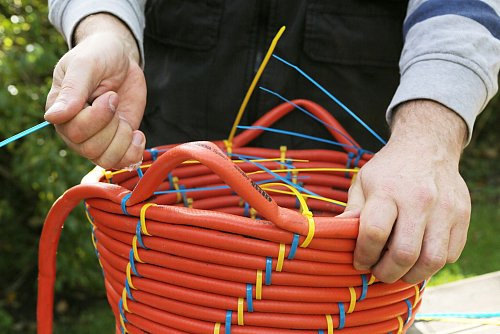 Der Gartenschlauch ist oll oder hat sogar ein Loch? Bindet man ihn zu einem Korb, stört das nicht weiter. - © diy-academy.eu/dpa-tmn