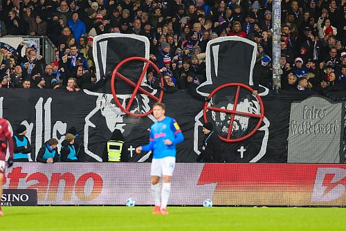 Die Kieler Fans sorgten mit einem Fadenkreuz-Banner für Wirbel. - © Frank Molter/dpa