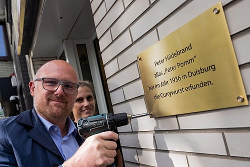 Mit der neuen Plakette macht Oberbürgermeister Sören Link (SPD) klar: Hier in Duisburg wurde die Currywurst erfunden. - © Rolf Vennenbernd/dpa