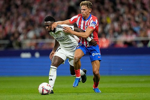 Kämpfen um den Sieg im Stadtderby von Madrid: Reals Vinicius Junior (l) und Atleticos Marcos Llorente. - © Bernat Armangue/AP