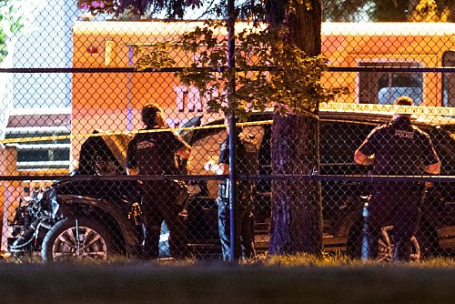 Polizisten untersuchen ein schwarzes Auto. - © Rich Lam/The Canadian Press/AP/dpa