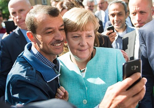 Die Wirkung ihres Selfies mit einem syrischen Flüchtling überrascht Merkel. - © Bernd von Jutrczenka/dpa