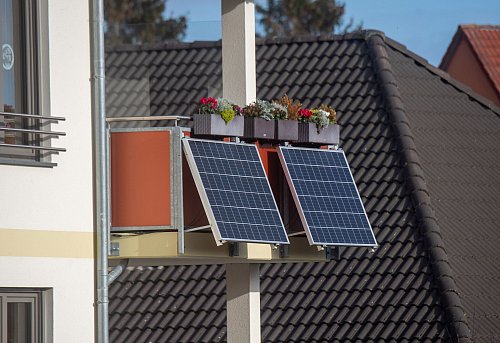 Solarmodule für ein sogenanntes Balkonkraftwerk hängen an einem Balkon. Mancherorts können Anträge auf Förderung von sogenannten steckerfertigen Balkon-Fotovoltaik-Anlagen gestellt werden. - © Stefan Sauer/dpa/dpa-tmn