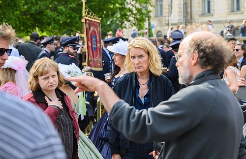 Die Schauspielerinnen Luise von Stein (l) und Maria Furtwängler stehen bei Dreharbeiten für einen neuen fiktiven „Tatort“ inmitten des realen Schützenausmarsches am Neuen Rathaus. - © Julian Stratenschulte/dpa