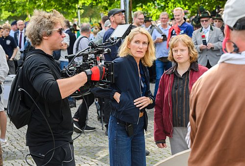 Die Schauspielerinnen Maria Furtwängler (l) und Luise von Stein spielen eine Szene bei Dreharbeiten für einen neuen fiktiven „Tatort“ inmitten des realen Schützenausmarsches am Neuen Rathaus. - © Julian Stratenschulte/dpa