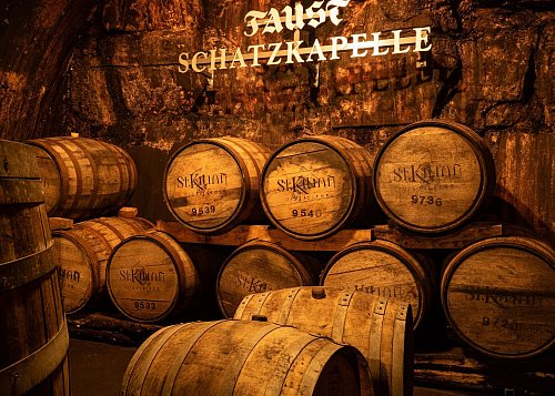 Es ist feucht und kühl in der Schatzkapelle der Brauerei Faust, wo Holzfässer im Dämmerlicht lagern. - © Andreas Drouve/dpa-tmn