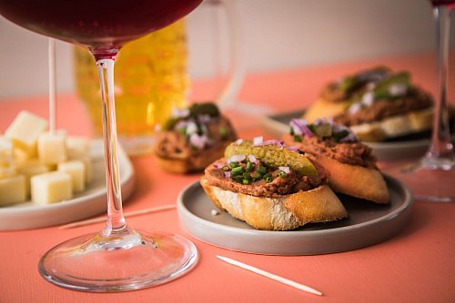 Ob als Fingerfood oder an der Bar: Borrelhapjes mit Filet Americain auf Baguette werden gern mit Cornichons, Zwiebeln und Käsewürfeln zu einem Drink gereicht. - © Christin Klose/dpa-tmn